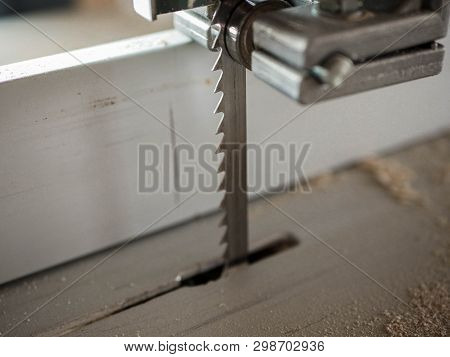 Bandsaw Blade Close Up Shot, Wood Dust And Chips On The Blured Background.