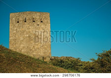 Stone Square Tower Over Rocky Hill With Lawn And Blue Sky In The Background, On Sunset At Guarda. Th