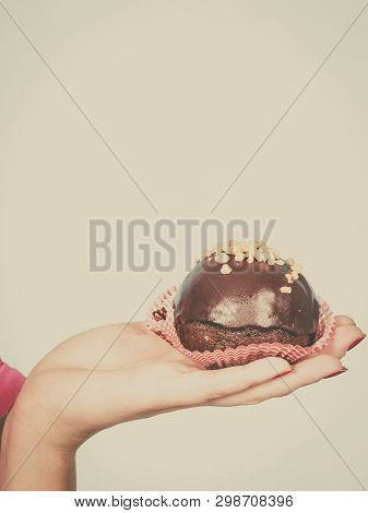 Diet, Sweets, Food Concept. Woman Hand Holding Delicious Chocolate Cupcake With Peanut Frosting Abou