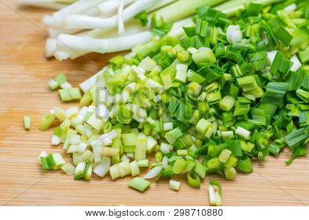 Chopped Green Garlic On Cutting Board Preparated For Cooking. Close-up Photo With Selective Focus.