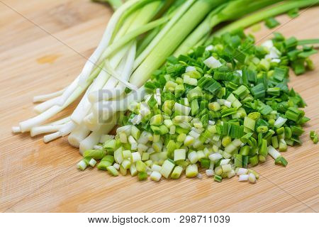 Chopped Green Garlic On Cutting Board Preparated For Cooking. Close-up Photo With Selective Focus.