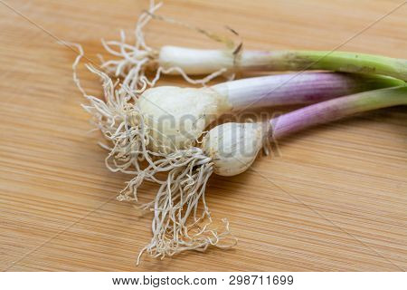 Raw Green Garlic On Cutting Board. Close-up Photo With Selective Focus.