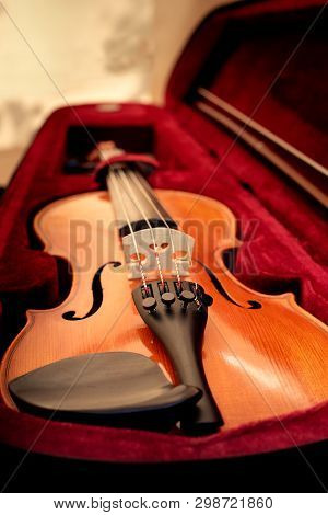 Violin And Bow In Dark Red Case. Close Up View Of A Violin Strings And Bridge