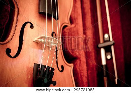 Violin And Bow In Dark Red Case. Close Up View Of A Violin Strings And Bridge