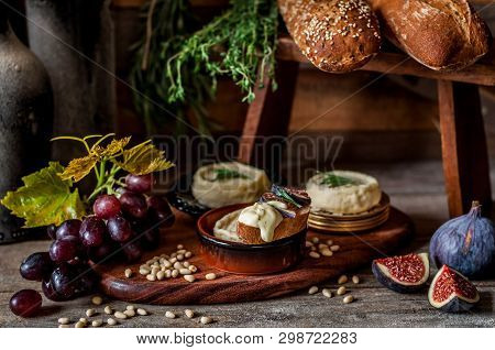 Soft Spreadable French Stinky Cheese On A Slice Of Bread With Fruit And Pine Nuts