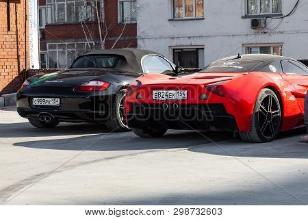 Novosibirsk, Russia - 05.01.2019: Marussia Motors Model B1 In Red Color And Black Porsche Boxster Fr