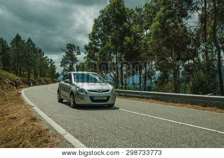 Serra Da Estrela, Portugal - July 15, 2018. Car Passing Through A Road On Hilly Landscape With Fores