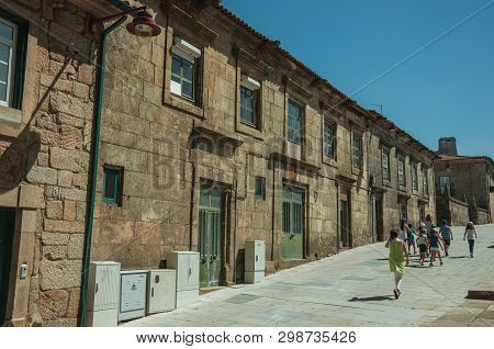 Guarda, Portugal - July 16, 2018. People Walking Next To Charming Long Building Made Of Stone At Gua