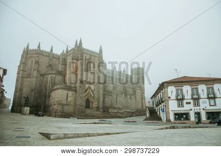 Cathedral Facade And Old Buildings In The Morning Mist