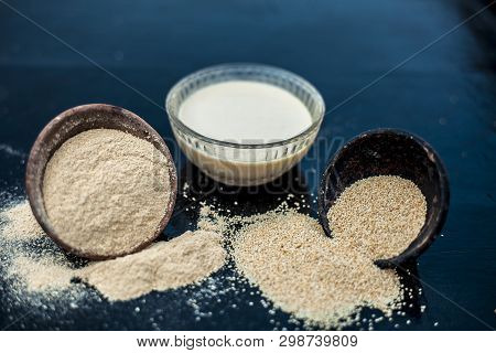Clay Bowl On Wooden Surface Full Of Poppy Seeds Or Khus Or Opium Poppy Or Bread Seed Poppy With Its 