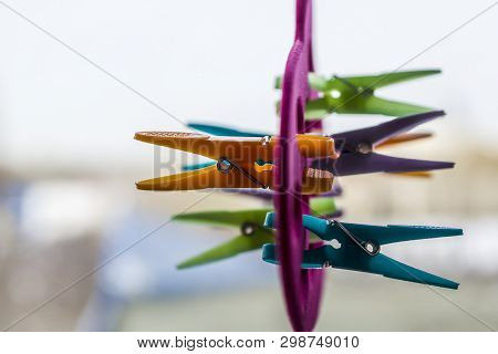 Multi-colored Clothespins Are Attached To A Hanger For Storing Shawls, Scarves And Stoles. Selective