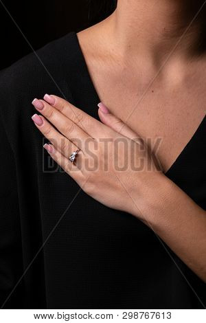 Womens Silver Ring With Diamond In The Shape Of Bear On Her Finger, On Black Background.