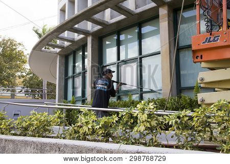 Bayamon/puerto Rico - February 26, 2019: Hispanic Man Uses High Pressure Washer Machine To Clean Ext