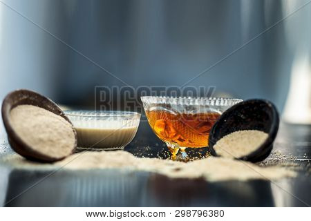 Clay Bowl On Wooden Surface Full Of Poppy Seeds Or Khus Or Opium Poppy Or Bread Seed Poppy With Its