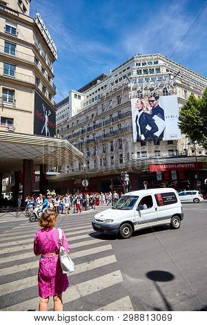 Paris, France - June 29, 2015: Boulevard Haussmann. A Woman At A Pedestrian Crossing In Front Of The