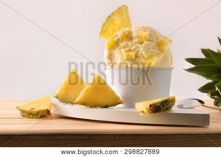 Pineapple Ice Cream Cup Decorated With Pineapple Chunks And Segments On A Wooden Table. Horizontal C