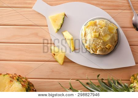 Pineapple Ice Cream Cup Decorated With Pineapple Chunks And Segments On A Wooden Table. Horizontal C