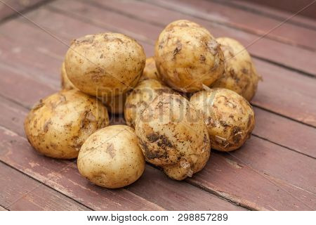 Many Fresh Potatoes On The Brown Table