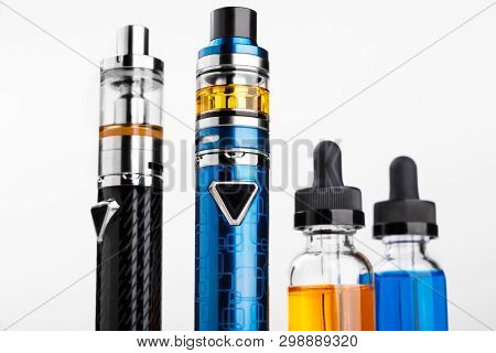 Electronic Cigarettes And Bottles With Vape Liquid On White Background