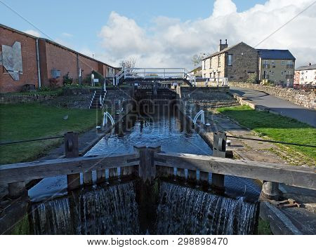 Oddy Locks On The Leeds To Liverpool Canal With The Historic Lock Keepers Footbridge And Wooden Gate