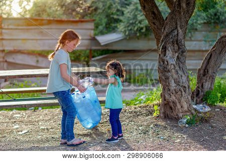 Two Kids Volunteer Charity Environment.children With Garbage Bags Cleaning Up Polluted Environmental