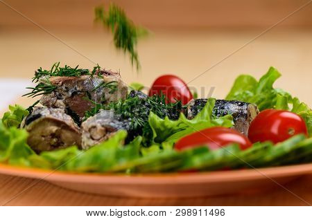 Pieces Of Sardine Iwashi On Lettuce Leaves With Red Tomatoes.