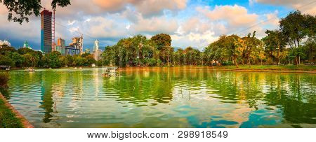 Panoramic view of Bangkok skyline, Thailand. View from Lumphini park. Pond on the foreground
