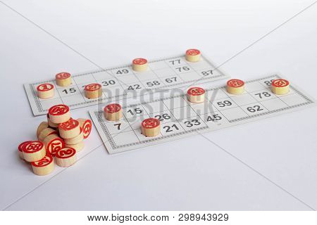 Bingo Or Lotto Game. Wooden Kegs Of Lotto On Cards. Cards And Chips For Playing Bingo On A White Tab