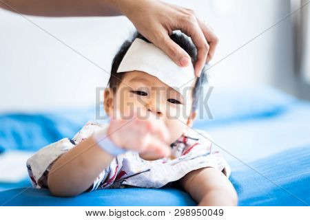 Unhappy Asian Little Baby Sick With Cool Fever Jel Pad On Forehead