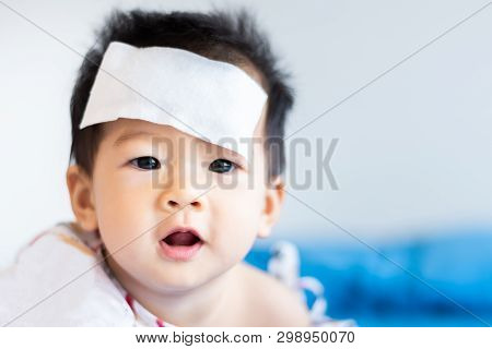 Unhappy Asian Little Baby Sick With Cool Fever Jel Pad On Forehead