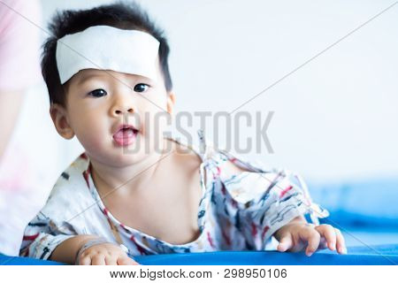 Unhappy Asian Little Baby Sick With Cool Fever Jel Pad On Forehead