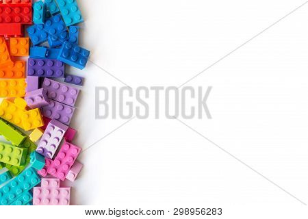 A Lot Of Colorful Plastick Constructor Bricks On White Background. Popular Toys. Copyspace
