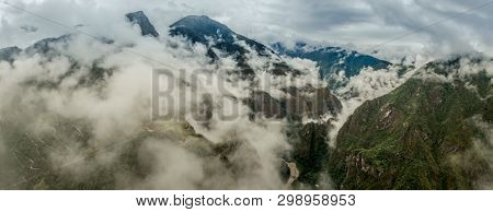 Majestic Machupicchu forested and covered with clouds, aerial view