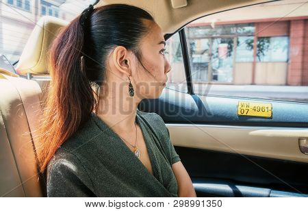 Bangkok, Thailand - May 02: Unnamed Asian Female Passenger Looks Out The Window As She Sits In Taxi 