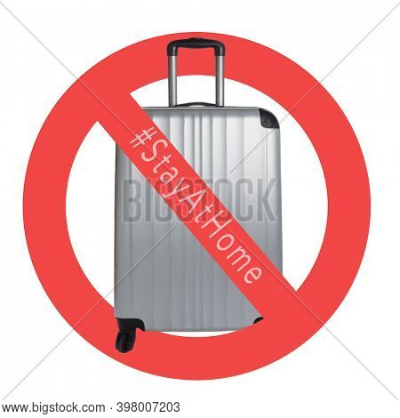 Silver Suitcase on a white background with international no symbol and #stayathome. Cancelled trip tourism restrictions concept during COVID-19 pandemic. 