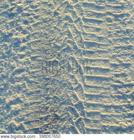 Tire Tracks Left In The Snow On A Bright Sunny Day. The Concept Of Snow Removal, Ski Resorts, Active