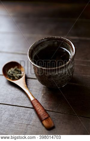 Green Tea (sencha) In A Traditional, Japanese Tea Cup And Sencha Leaves On A Wooden Tea Spoon. Dark 