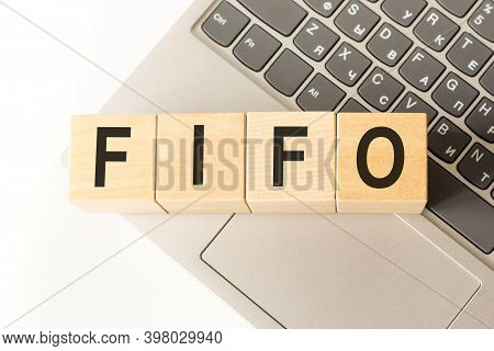 Word Fifo. Wooden Cubes With Letters Isolated On A Laptop Keyboard. Business Concept Image.
