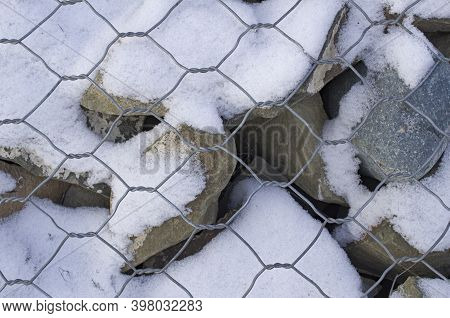 Large Mountain Sharp And Round Stones Were Enclosed Under A Steel Mesh In The Form Of Honeycombs
