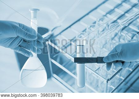 Flask In Scientist Hand With Dropping Chemical Liquid To Test Tubes, Science And Medical Research An