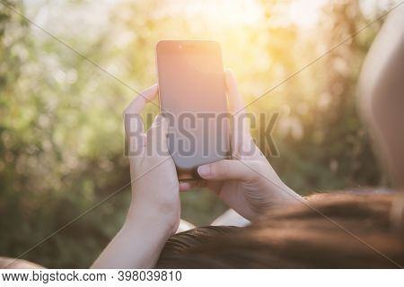 Woman With Smartphone Outdoors In Park. Closeup Of Female Hands And Smart Phone On Empty Screen ,sun