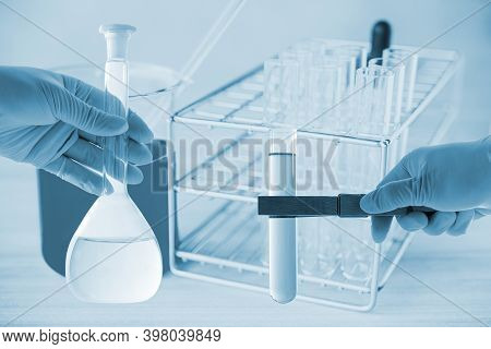 Flask In Scientist Hand With Dropping Chemical Liquid To Test Tubes, Science And Medical Research An