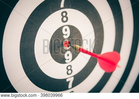 Red Dart Arrow Hitting In The Target Center Of Dartboard