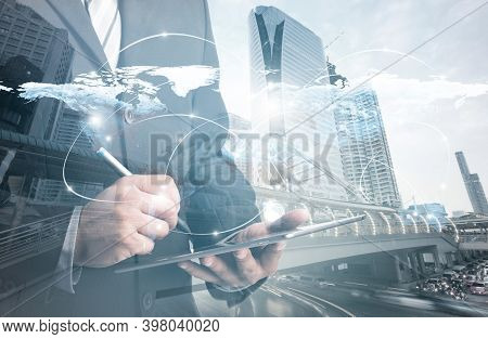 Double Exposure Of Success Businessman Using Digital Tablet With City Landscape Background.connectio