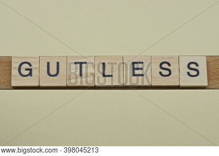 Gray Word Gutless Made Of Wooden Square Letters On Brown Background
