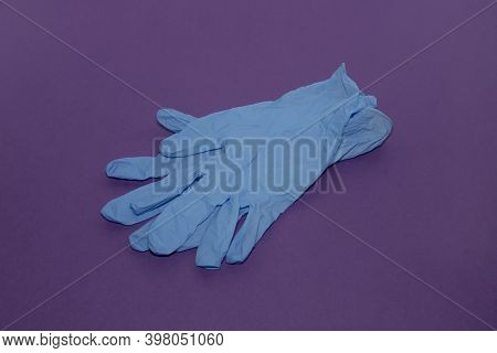 Blue Medical Gloves On A Purple Background.