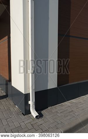 White Drainpipe At The Corner Of The Building.