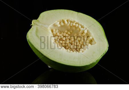 Half Green Round Papaya On Black Background With Reflection.