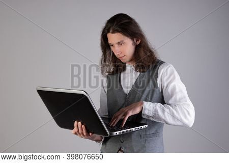 Programming And Writing Code, Developing Software Products. Geek Guy, With Long Hair And Glasses, Ho