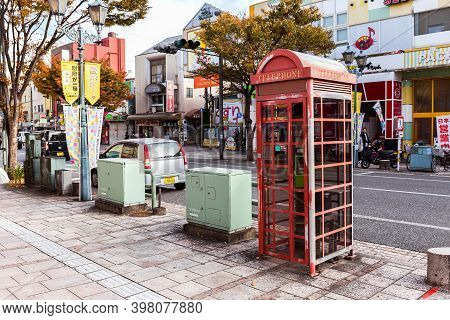Beppu, Oita, Kyushu, Japan, November 12, 2017: An Old Scuffed Telephone Booth On A Street In The Jap